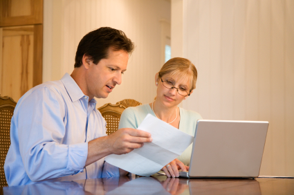 Husband and wife paying bills on computer.